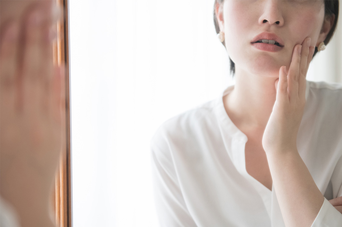 顔のそばかすを気にする女性