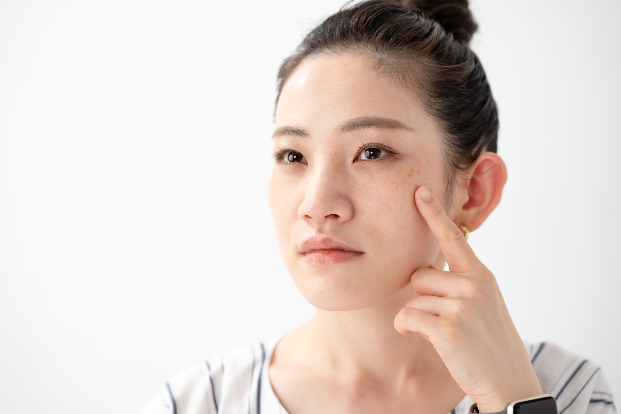 頬にできたしみを気にしている女性